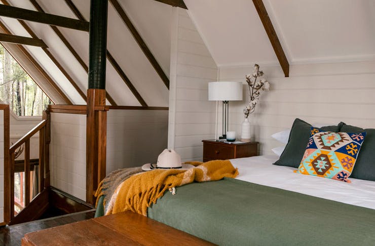 A bedroom with Montana-inspired cushions, and a green duvet.
