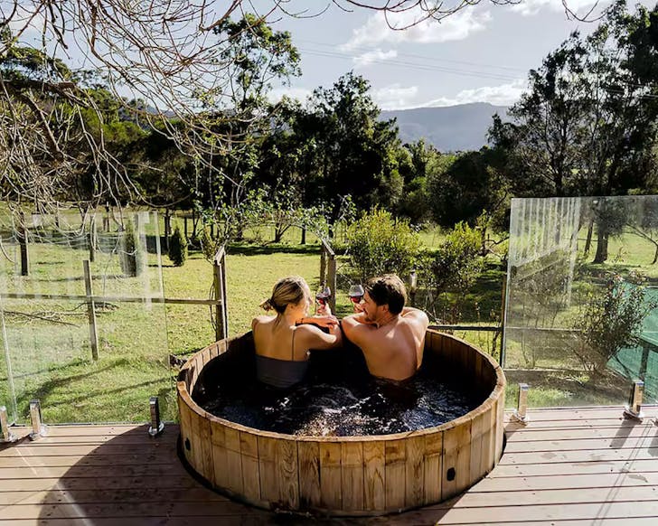 A view of the hot tub and garden at Jamberoo Valley Farm Cottage Airbnb near Sydney NSW