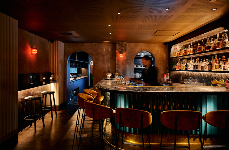 A moody round bar with tall leather seats surrounding the bar. It's at Bar Jayda, one of the best bars Melbourne has to offer in 2024