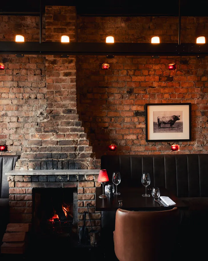 A brick-lined steak house, with a fireplace. 