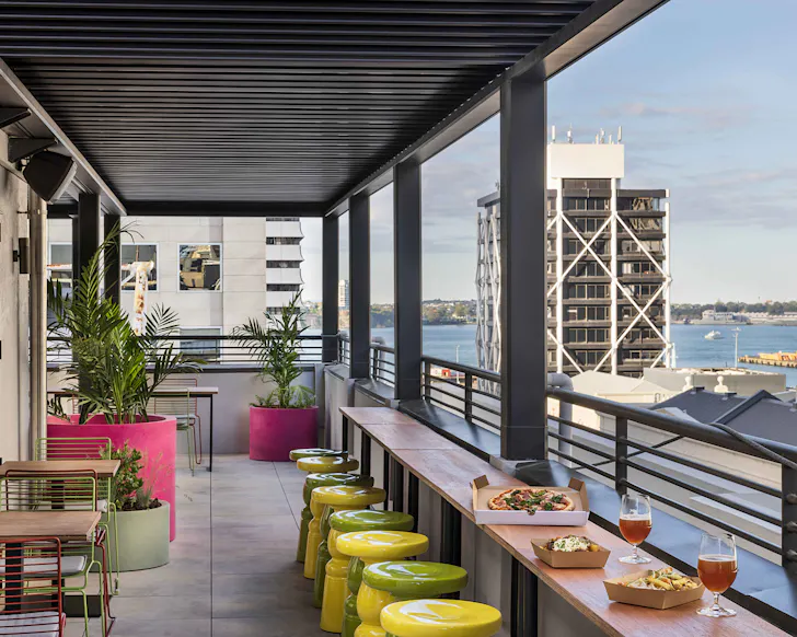 A cute, colourful rooftop bar with boxed pizzas and dranks.