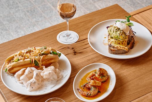 A table will different dishes and a glass of wine.