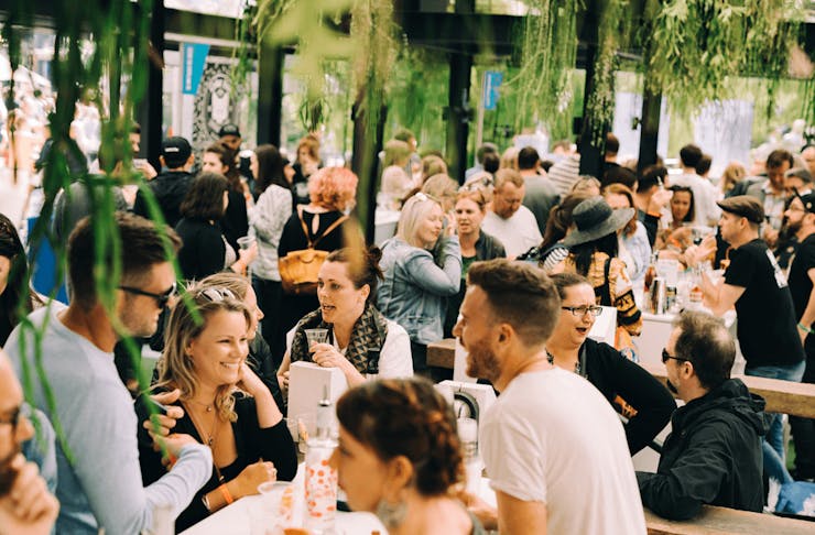 A group of people drinking in a beer garden. 