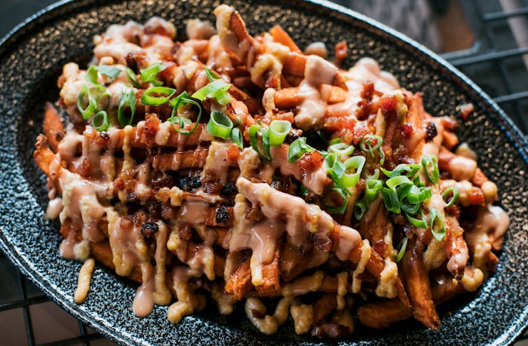 Loaded fries covered in sauce.