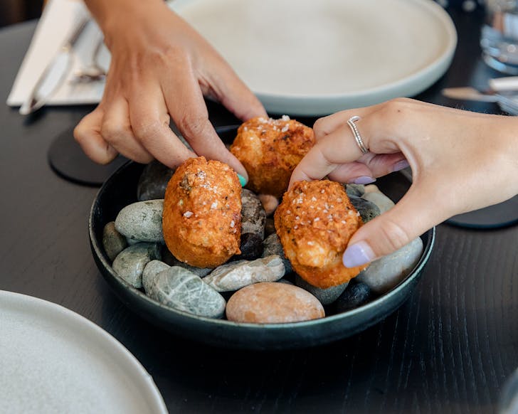 Two people pick up crunchy bites from KOL. 