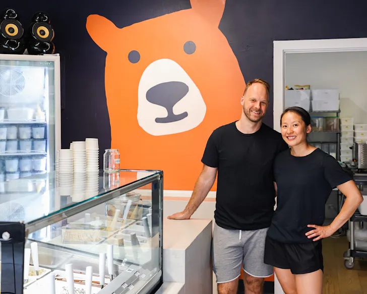 Kahwen and Ryan stand together in Bear Gelato, smiling. 