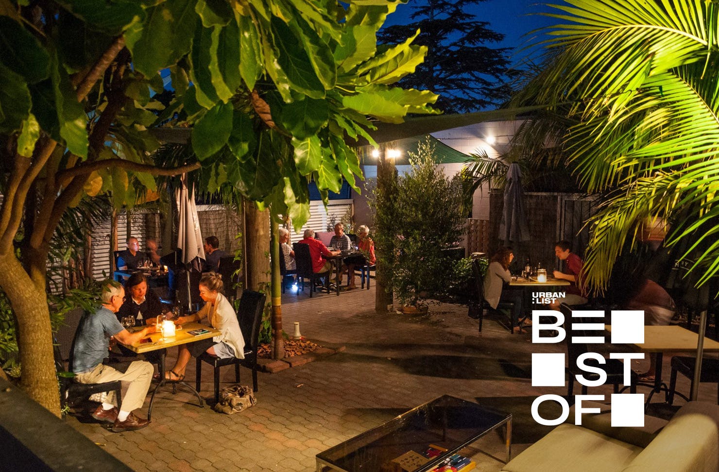 People sit in the courtyard at KaiZen, one of the best restaurants in the coromandel