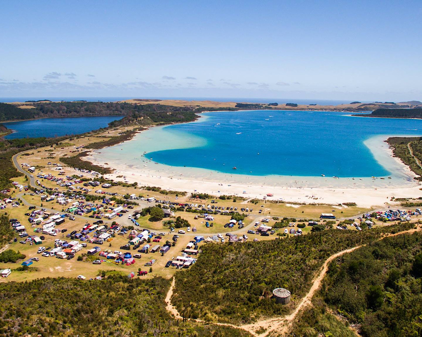 An aerial shot of gorgeous blue water lakes and a large camping ground. 