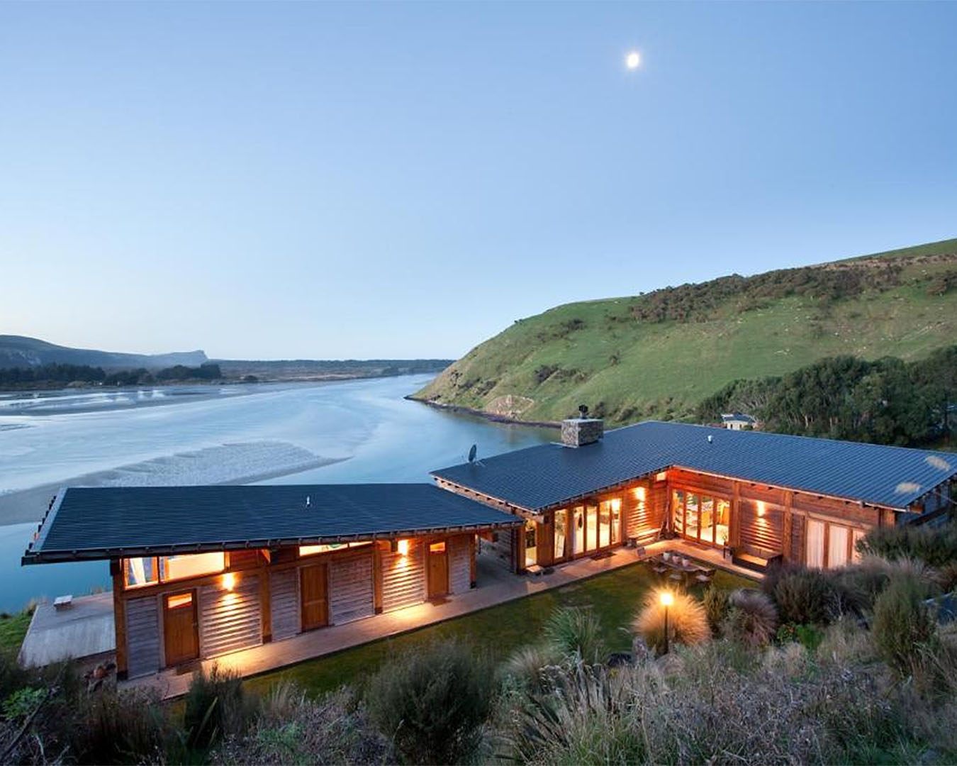 An impressive lodge overlooks the water at dusk in Dunedin.
