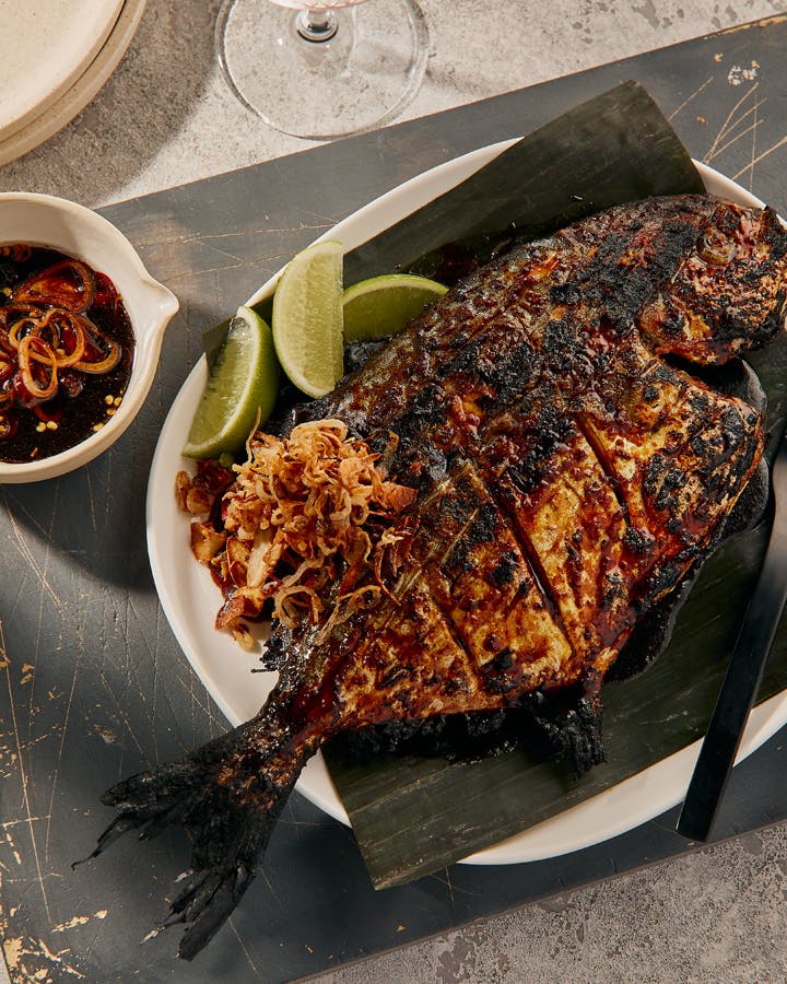 A large grilled fish on a table at a Indonesian restaurant Melbourne. 