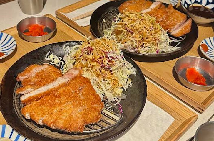 Two plates of krispy katsu with slaw. 