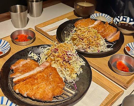 Two plates of krispy katsu and slaw. 