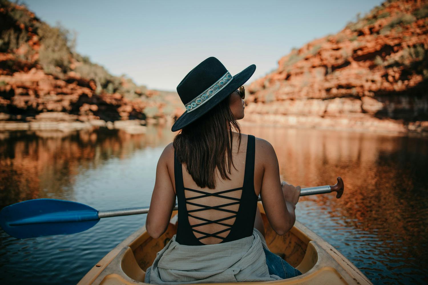 A woman kayaks along a calm lake in WA.