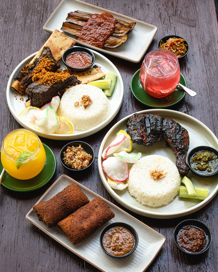 A table filled with different dishes and drinks at best Indonesian restaurant Melbourne.