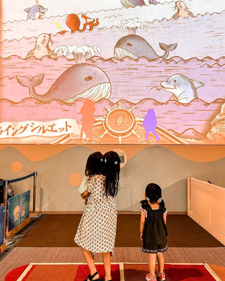 A family of three at the entrance of Kids Plaza Osaka. 