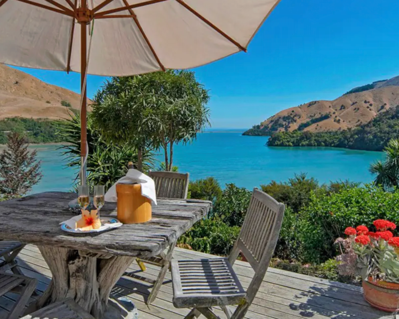 Outdoor table and chairs on deck with stunning views of the sea in Nelson