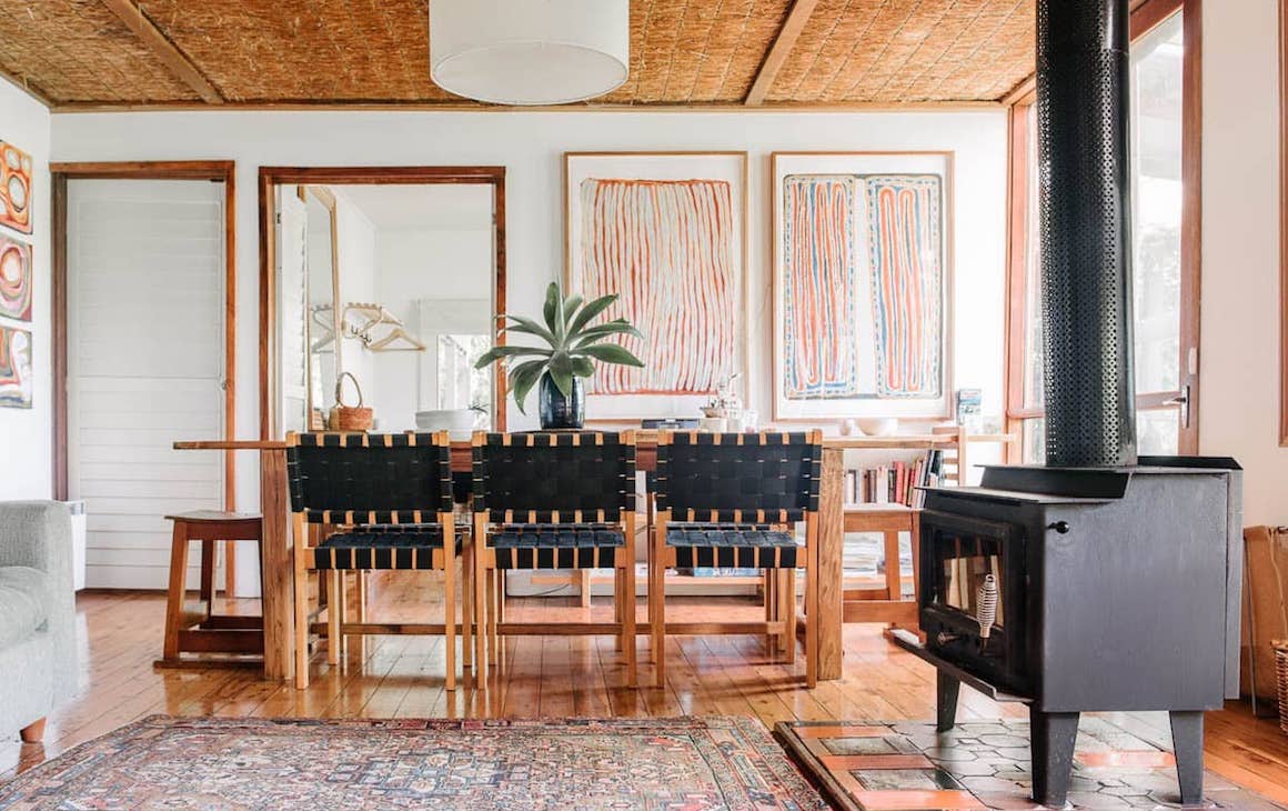 A colourful dining room with fireplace and artwork across the walls at one of the best romantic getaways in Victoria.