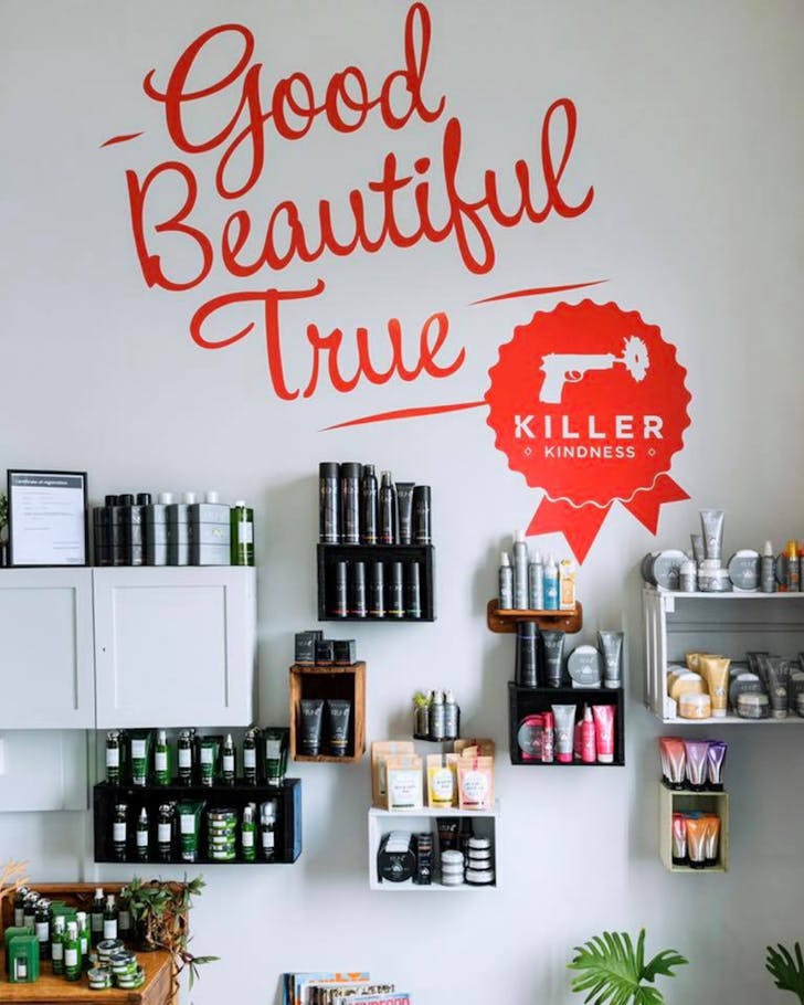 A wall with shelves displaying hair products inside the salon.