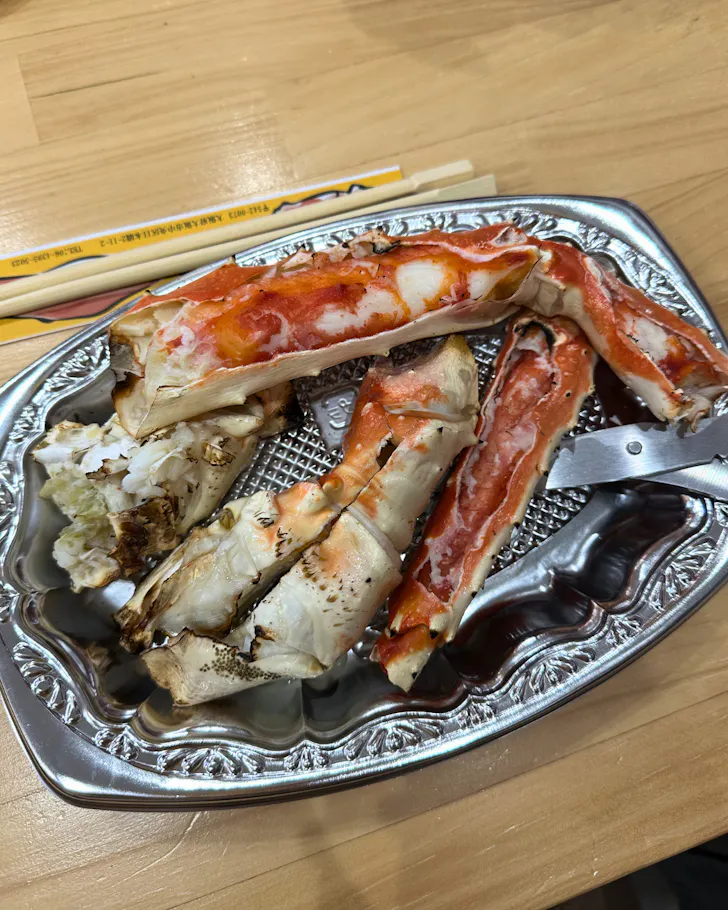 A silver platter of King Crab legs at a street food stall in Dotonbori.
