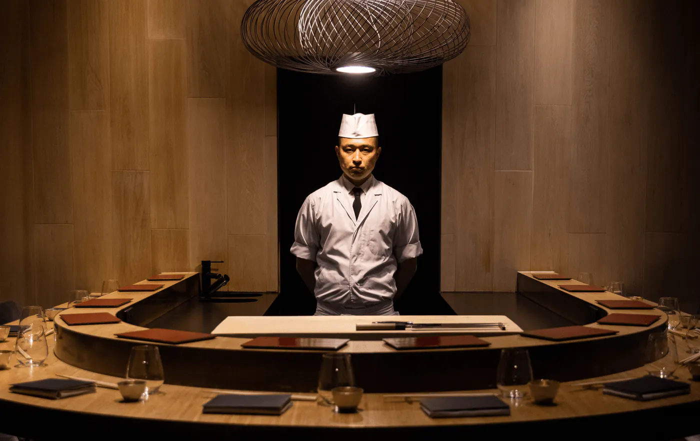 A chef standing inside a private dining space. 