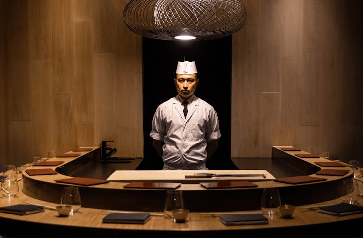 A chef standing inside a private dining space. 