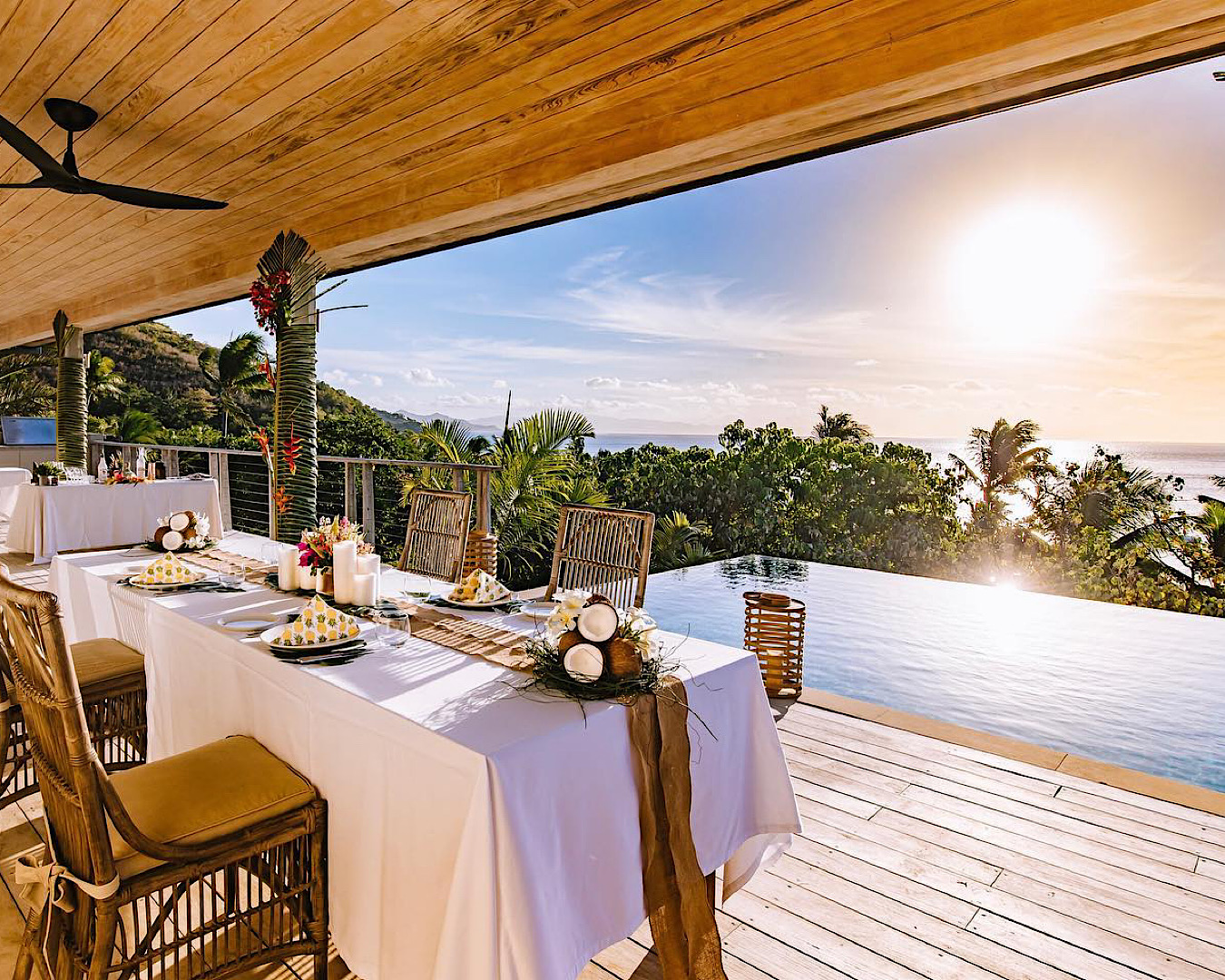 A beautiful meal setting on a deck with an infinity pool and sea views at Kokomo Private Island.