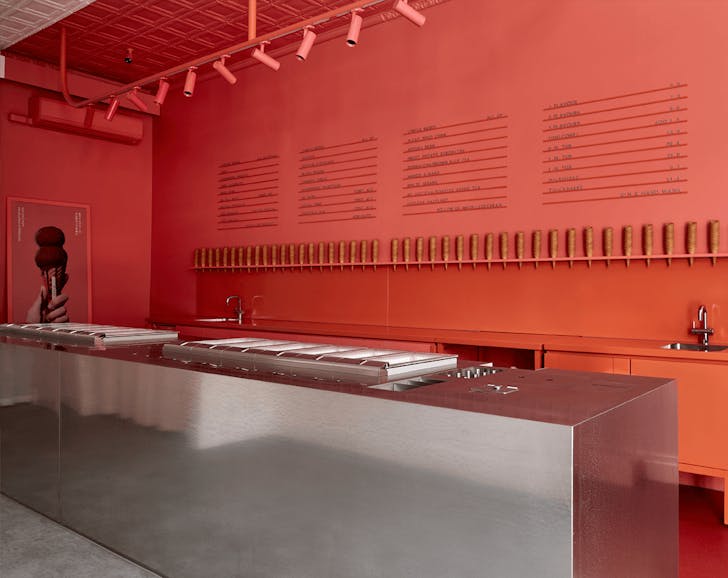 A large red wall with a metal island bench.