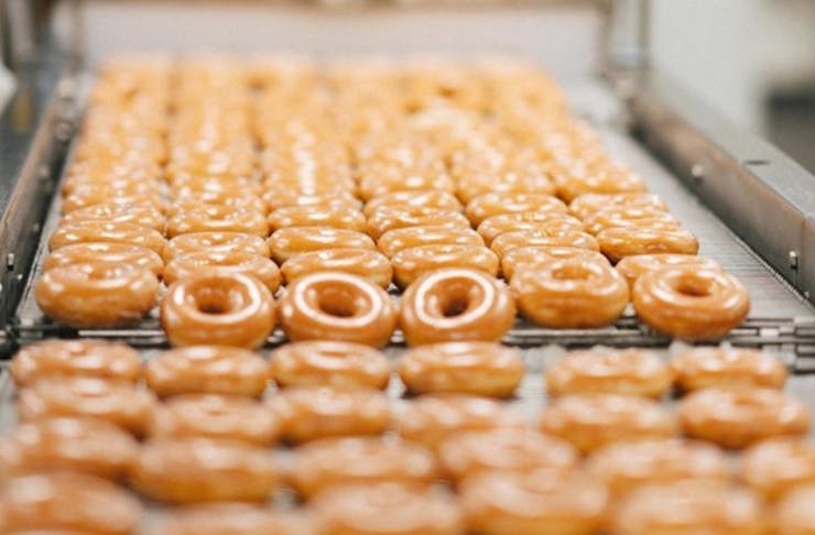 Krispy Kreme Doughnuts on a conveyor belt