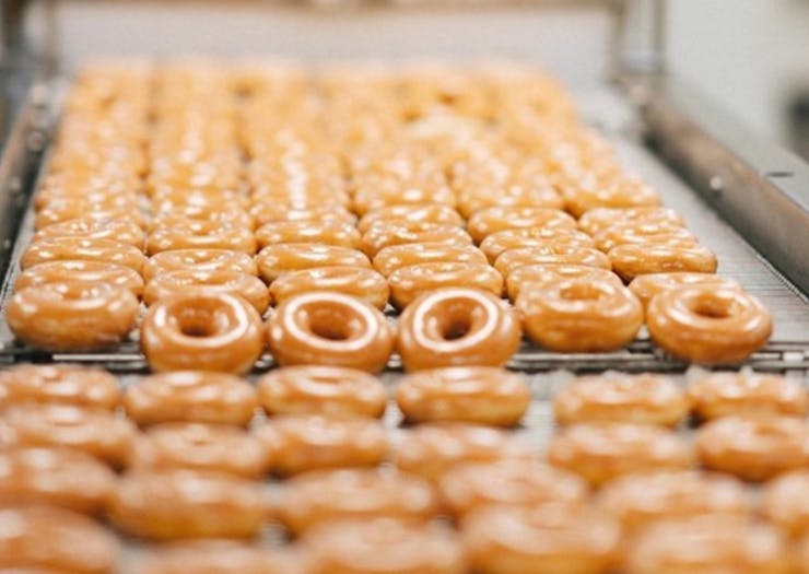 Krispy Kreme Doughnuts on a conveyor belt