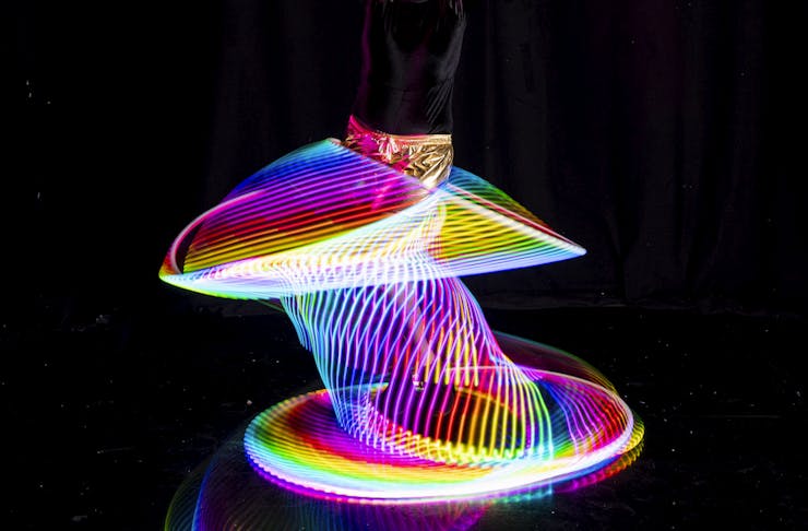 A person hooping with LED hoops around their waist and legs
