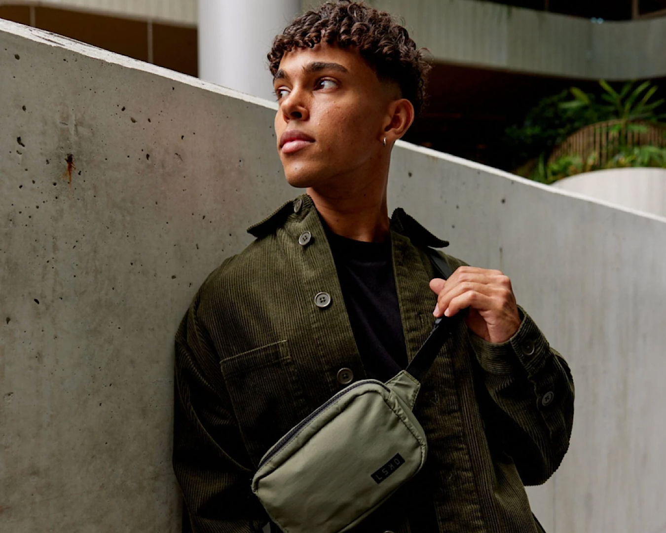 A male model wears an olive fade cross body bag by LSKD, one of the best Christmas gifts under $50.