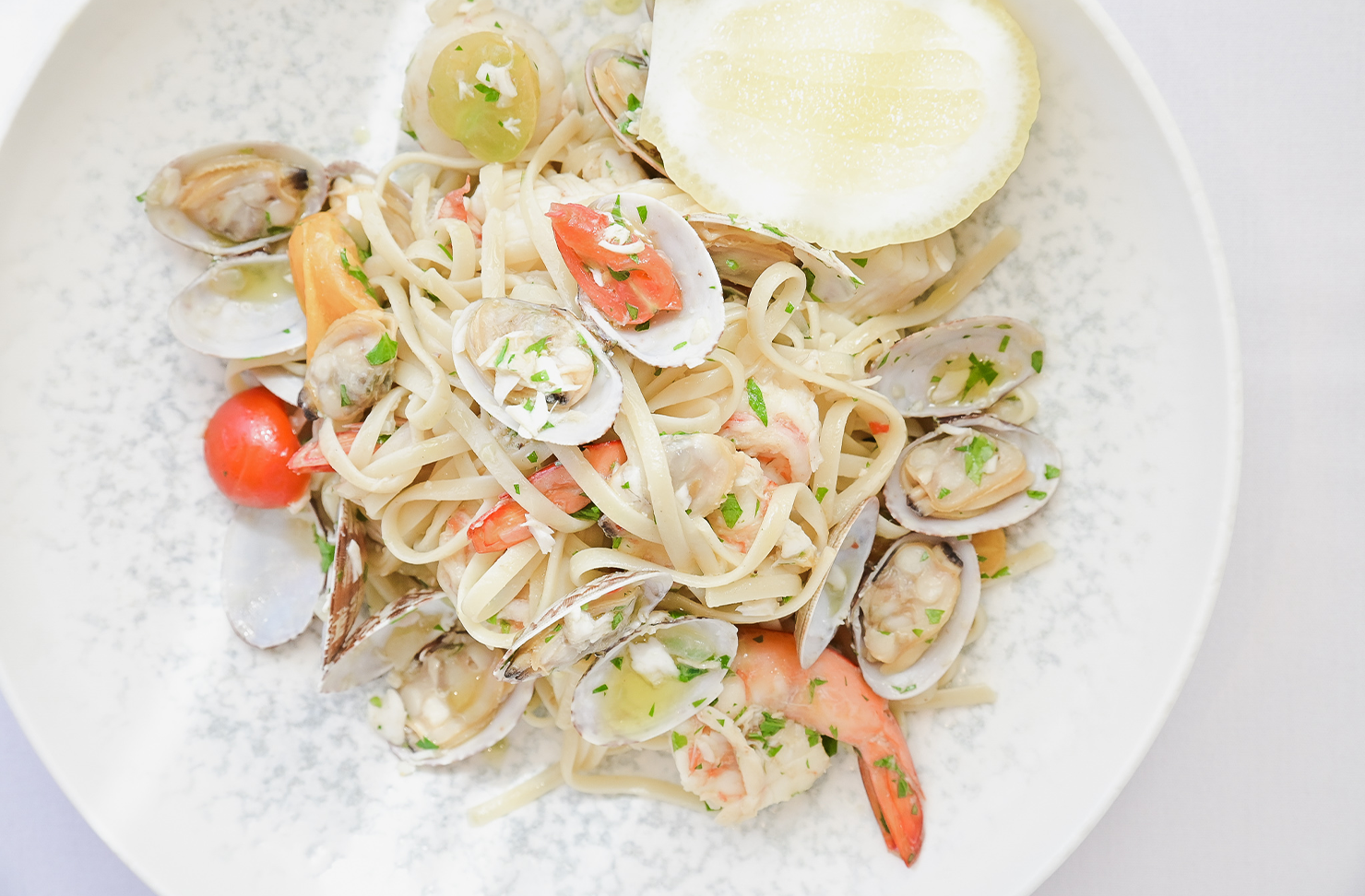a closeup shot of seafood linguine on a white plate