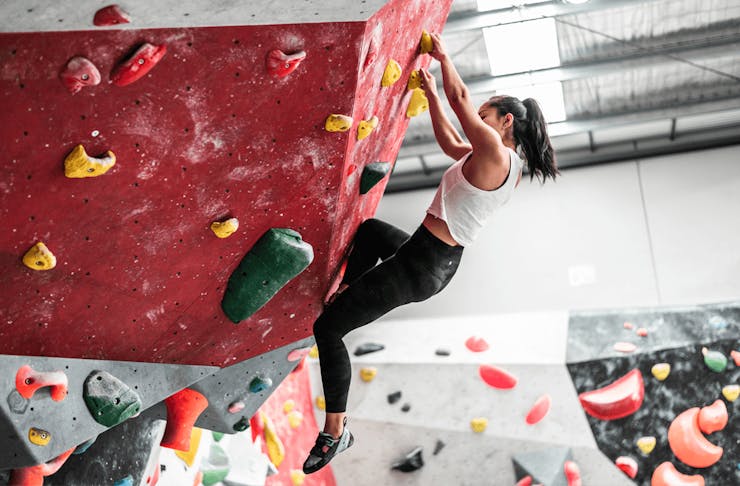 A person bouldering on a wall. 