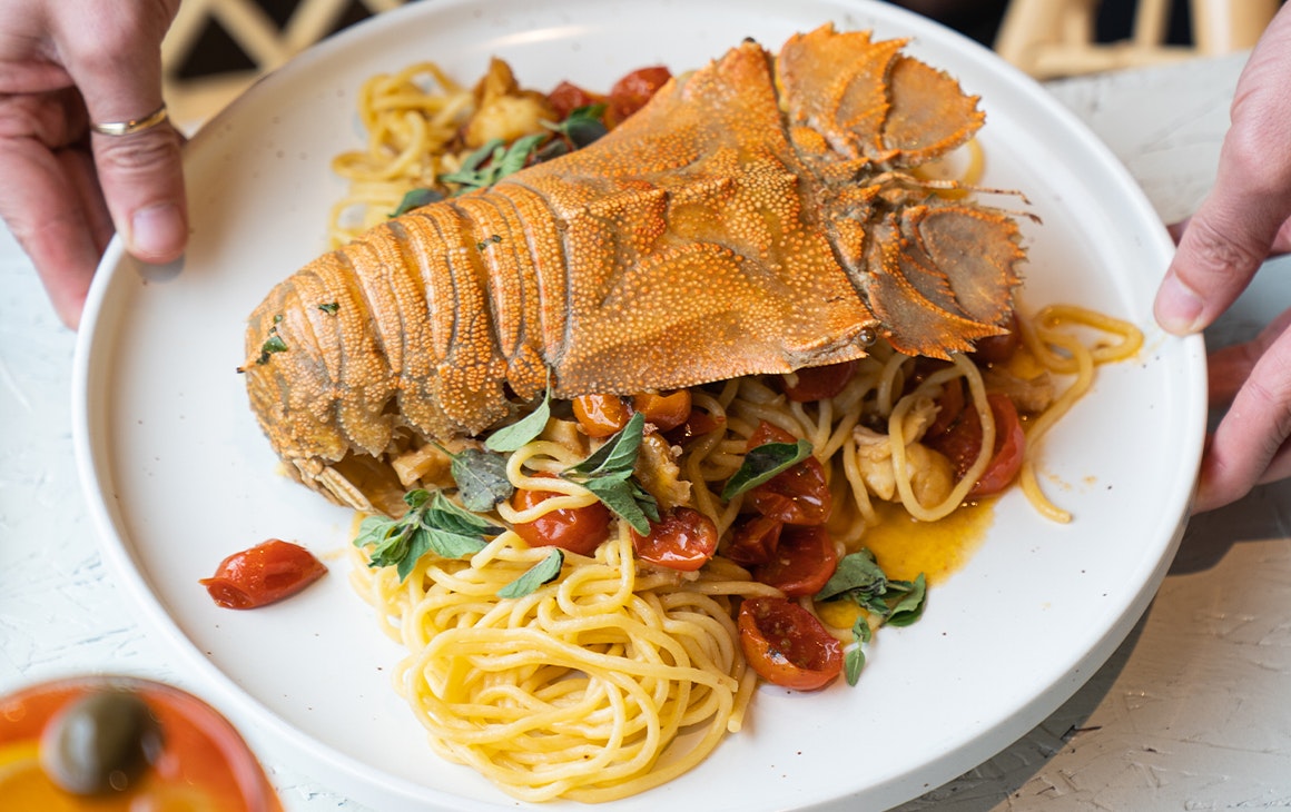 a plate of spaghetti with moreton bay bug on top