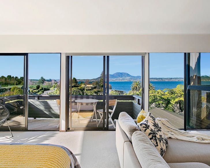 A wicked cool view of Lake TaupÅ through bifold doors at Lago Visto, one of the best Airbnbs in TaupÅ.