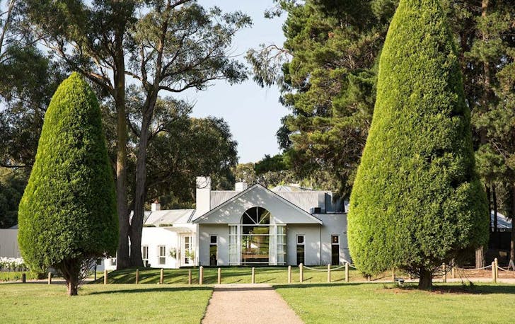 A large white house surrounded by trees, a top winery accommodation Victoria option.