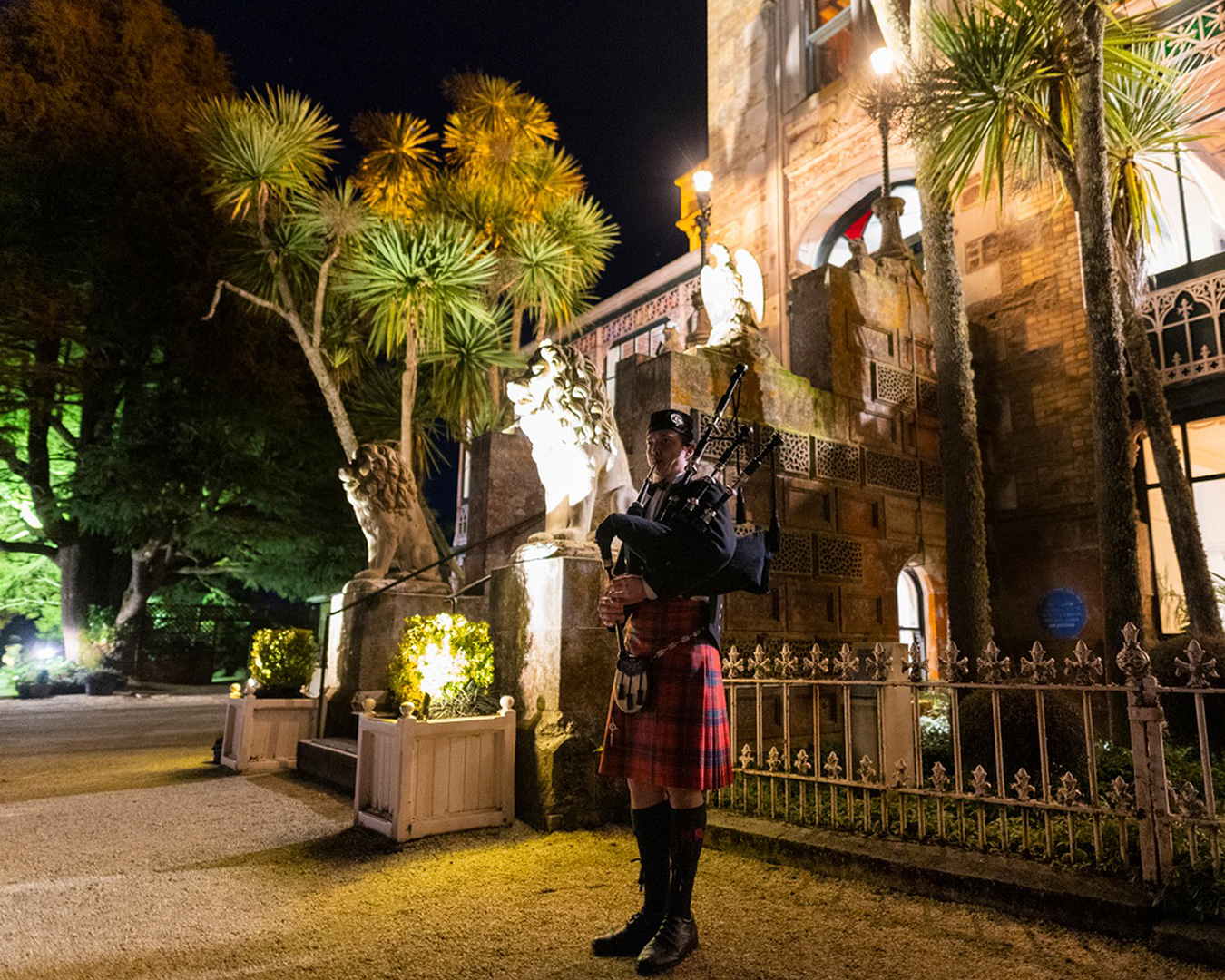 A lone piper stands outside Larnach Castle, one of the most haunted places in NZ.
