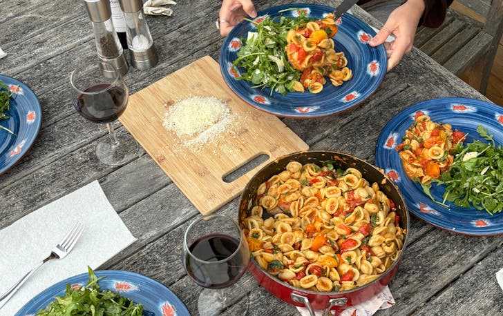 Home cooked pasta and salad on outdoor dining table