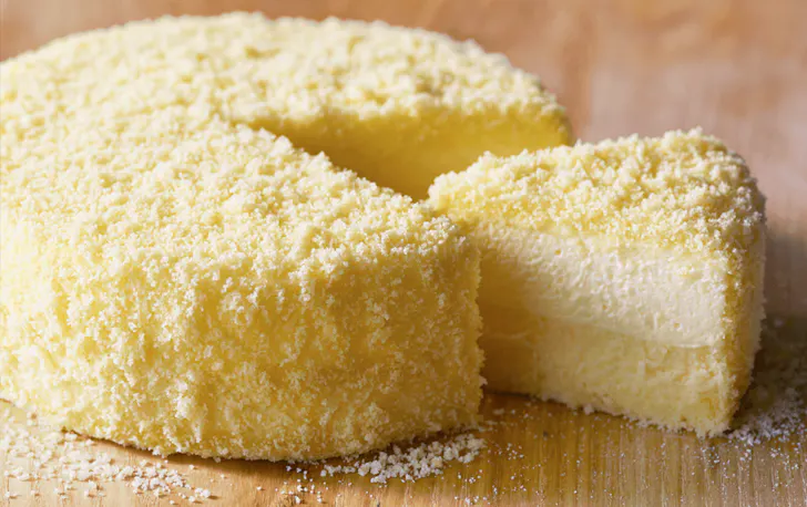A large creamy cheesecake with a slice carved out of it. 