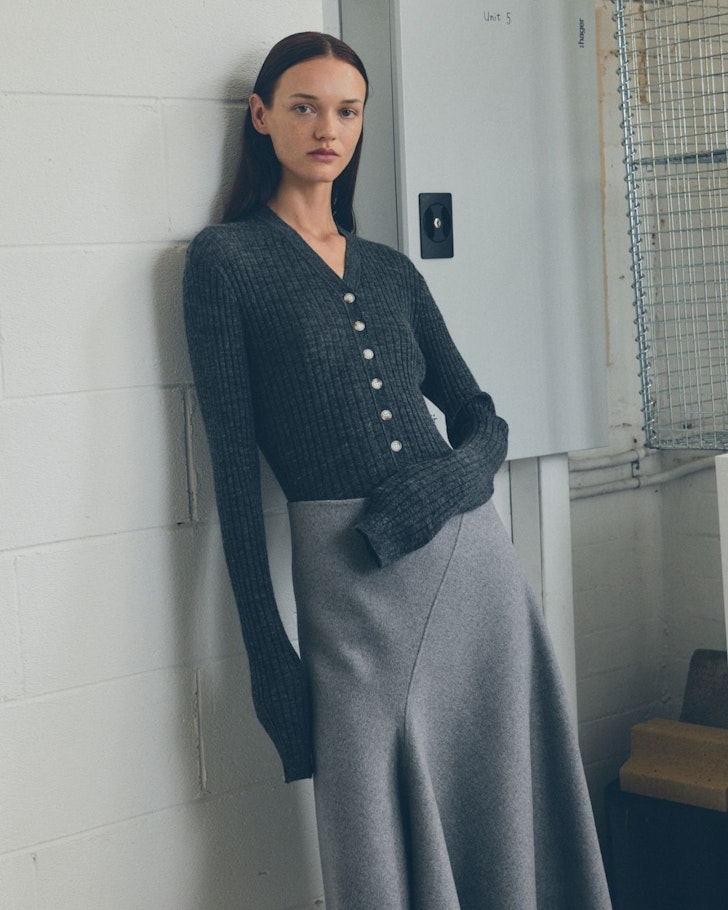 A woman in a cardigan and skirt by Lee Matthews one of the best Australian fashion labels