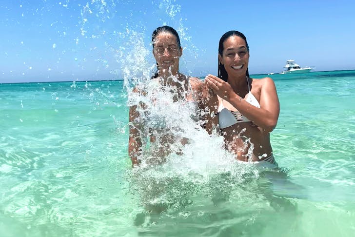 Two woman play in the blue waters of the south pacific