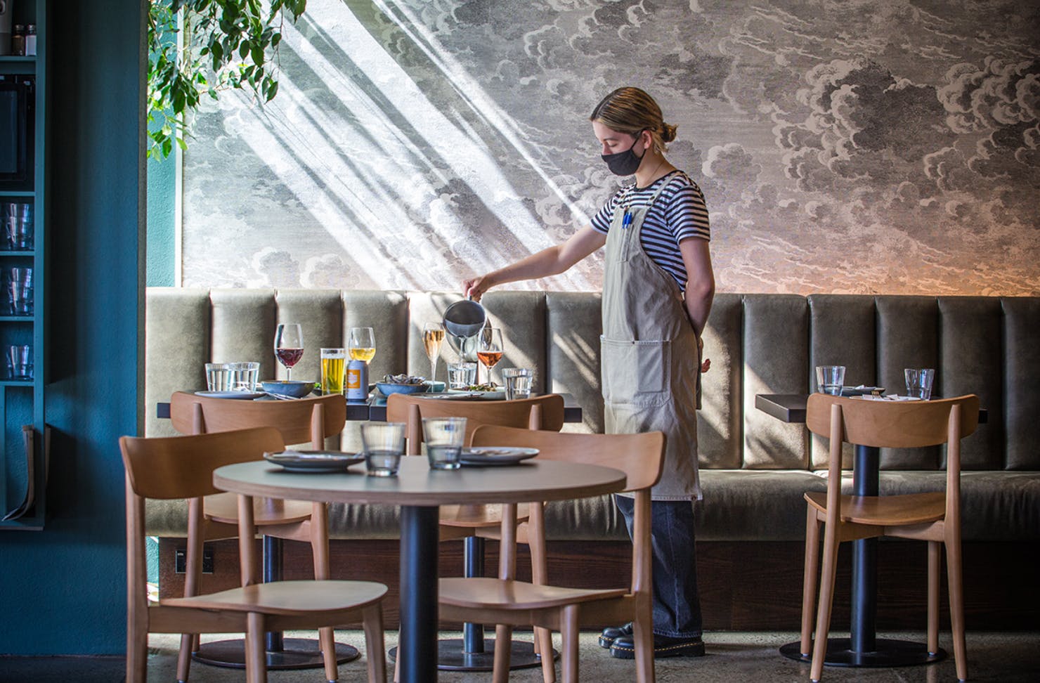 Waitress pouring water into a glass