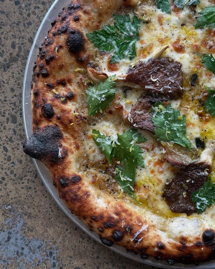 A mushroom pizza woodfired to perfection at Lillies, one of the best Italian restaurants in Christchurch. 