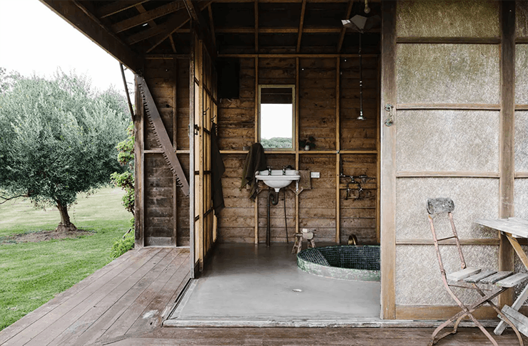 A large rustic bathhouse with a tiled spa at one of Victoria's best outdoor bath spa Airbnb.