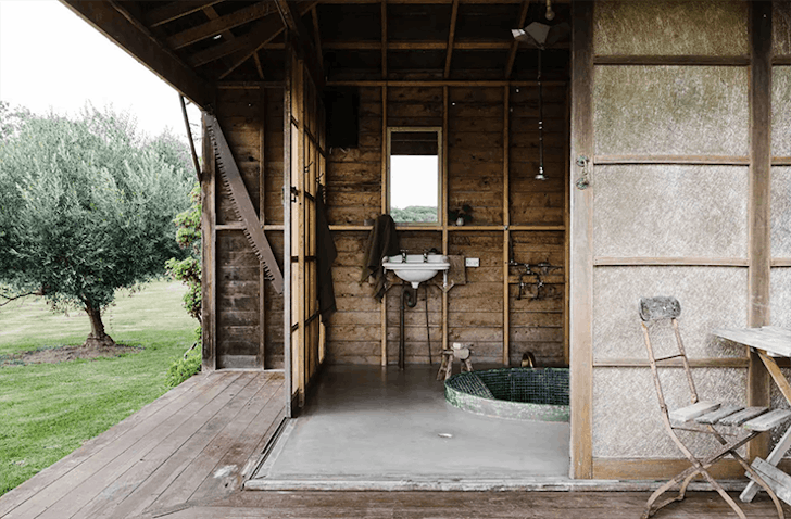 A Japanese-style bath sits outside undercover in a timber hut.