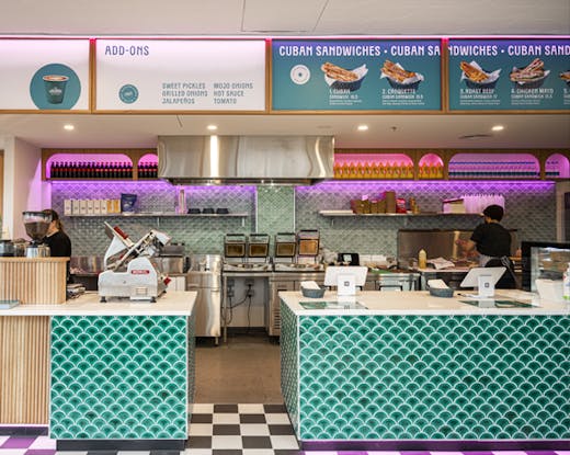 The inside of a deli with neon lights. 