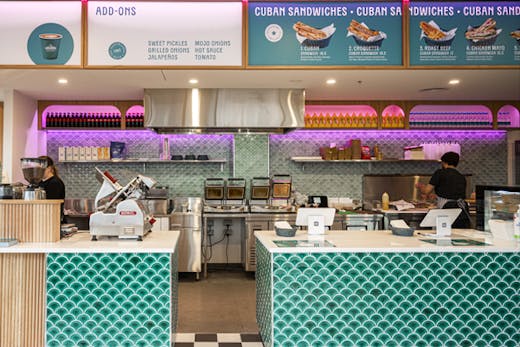 The inside of a deli with neon lights.