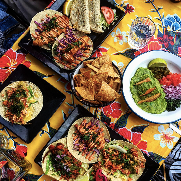A table with different tacos and corn chips at one of the best Mexican restaurants in Melbourne.