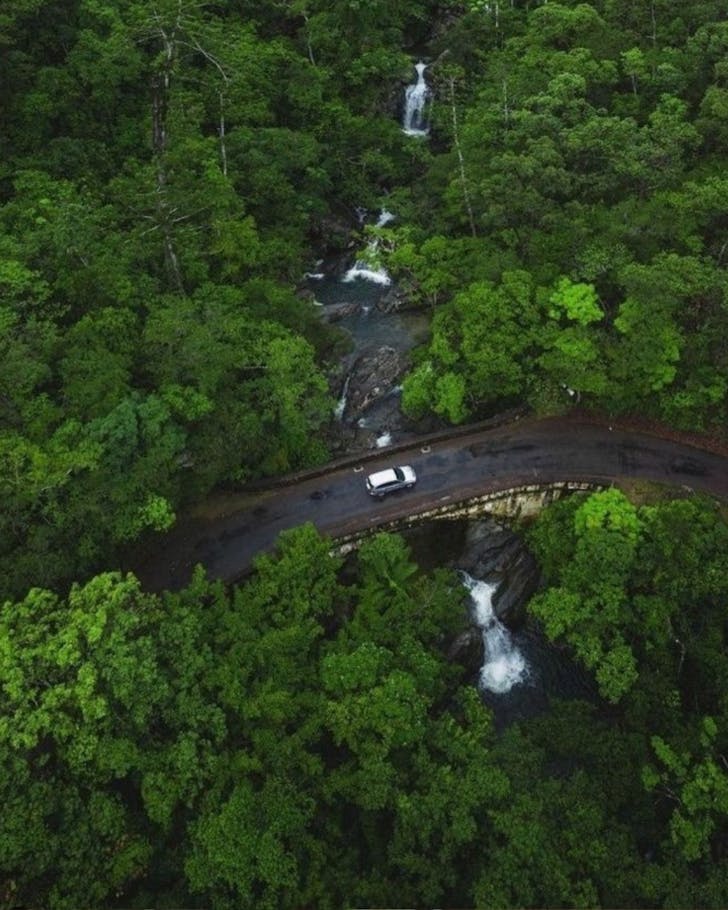 A drone shot of Little Crystal Creek cascading under a road in Paluma Range National Park.