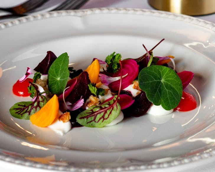 White plate filled with bright, colourful beetroot and feta salad